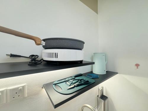 a kitchen shelf with scissors and other items on it at Weekly Monthly Stay - Subang Jaya Edumetro SEGI Atira in Subang Jaya