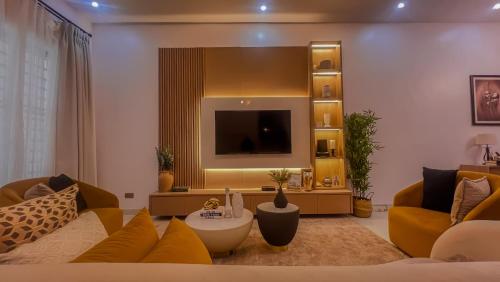 a living room with a couch and a tv at Westbrook Homestay LekkiLuxury 4 bedroom with 24 power,PS5&Security in Lekki