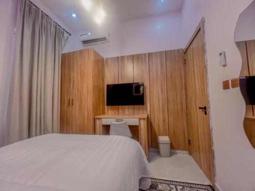 a hotel room with a bed and a television at Westbrook Homestay LekkiLuxury 4 bedroom with 24 power,PS5&Security in Lekki