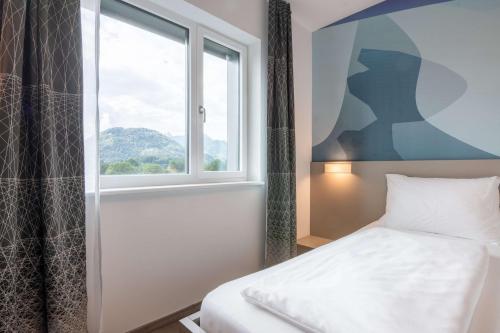 a bedroom with a bed and a window at Best Western Hotel Kiefersfelden in Kiefersfelden
