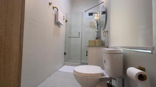 a white bathroom with a toilet and a shower at Westbrook Homestay LekkiLuxury 4 bedroom with 24 power,PS5&Security in Lekki