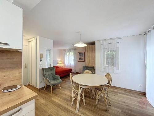 une cuisine et un salon avec une table et des chaises dans l'établissement Studio cosy proche Thermes et centre-ville avec terrasse, animaux acceptés – Lamalou-les-Bains - FR-1-451-67, à Lamalou-les-Bains