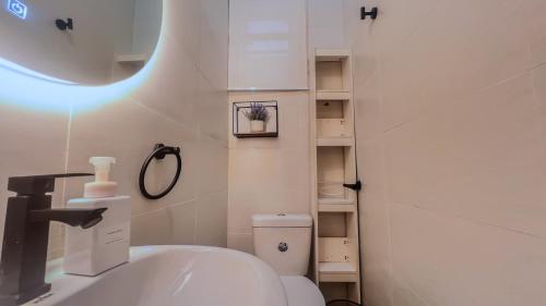 a bathroom with a sink and a toilet and a mirror at Westbrook Homestay LekkiLuxury 4 bedroom with 24 power,PS5&Security in Lekki
