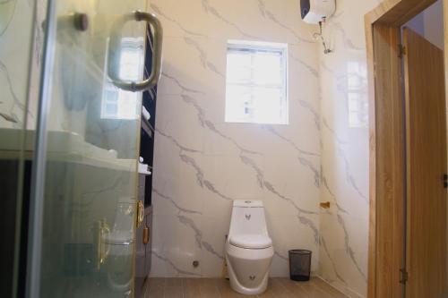 a bathroom with a toilet and a shower at Westbrook Homestay LekkiLuxury 4 bedroom with 24 power,PS5&Security in Lekki