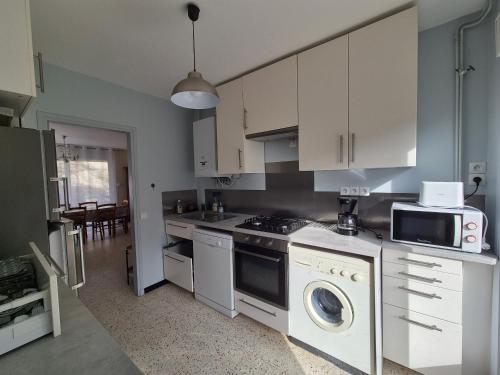 une cuisine avec des armoires blanches et un four à plaques de cuisson dans l'établissement Maison à 50m de la plage, 3 chambres, jardin clôturé, idéale en famille! - FR-1-482-85, à Fort-Mahon-Plage