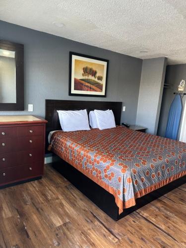 a hotel room with a bed and a dresser at Fireside Inn By The Beach Boardwalk & Bowling in Santa Cruz