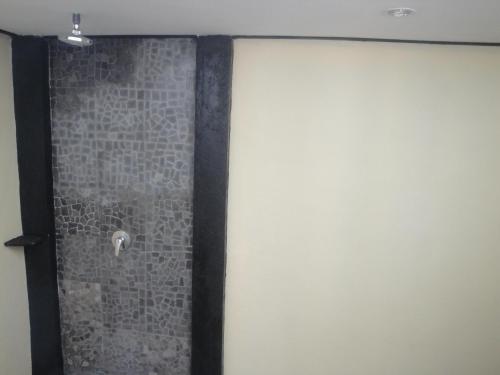 a shower in a room with a brick wall at Bedolo Bungalows in Gili Air