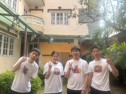 a group of four men standing in front of a house at Hotel Chhimeki in Kathmandu