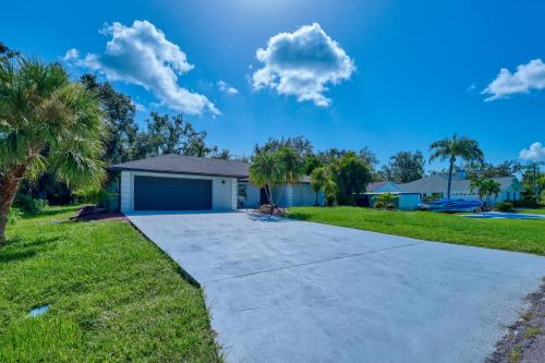 ein Haus mit Palmen und einer Auffahrt in der Unterkunft Modern and Spacious 3bdrm and 3 bath house with pool in Port Charlotte