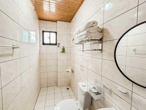 a white bathroom with a toilet and a mirror at 澎湖樂在綺中民宿 第580號 in Magong
