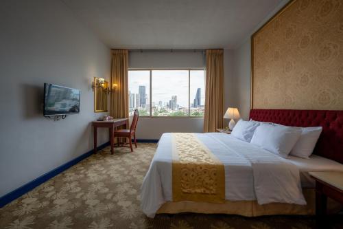 a hotel room with a large bed and a window at Ariston Hotel Bangkok in Bangkok