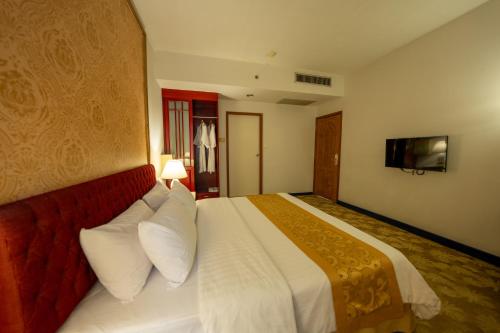 a hotel room with a bed with a red couch at Ariston Hotel Bangkok in Bangkok