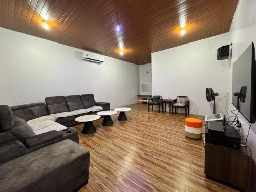 a living room with a couch and two tables at Olly de Home Ent in Batu Gajah