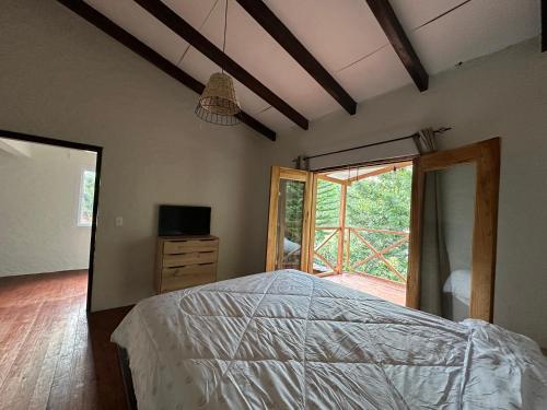 a bedroom with a bed and a large window at Villa Napoleón in Valle de Ángeles