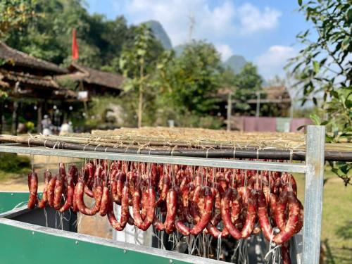 a bunch of sausages being cooked on a grill at Mế farmstay in Cao Bằng