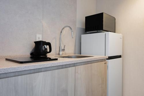 a kitchen with a sink and a white refrigerator at Minn STATION Ai Nagoya in Aoichō
