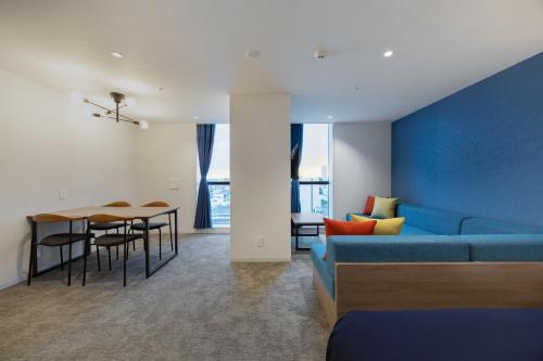 a living room with a blue couch and a table at Minn STATION Ai Nagoya in Aoichō