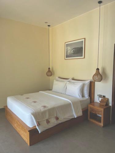 a bedroom with a large bed with white sheets and pillows at Tropical Almond Villa in Uluwatu