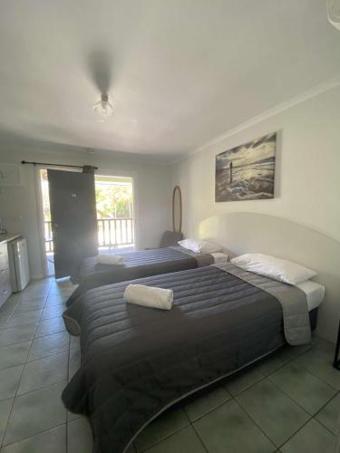 a bedroom with two beds and a window at Agnes Palms Motel in Agnes Water