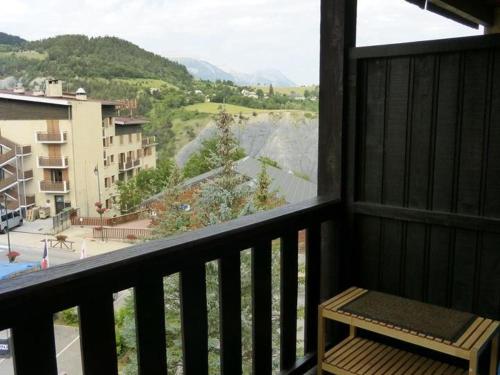 a balcony with a bench and a view of a city at Studio 25m² au Sauze, balcon Sud-Ouest, proche pistes - FR-1-804-15 in Enchastrayes