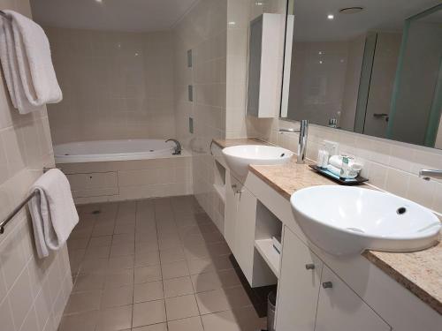 a white bathroom with a sink and a bath tub at Pavillions on 1770 in Agnes Water