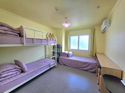 a room with two bunk beds and a desk at Happy Garden Guesthouse in Seoul