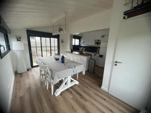 une salle à manger avec une table blanche et une cuisine dans l'établissement Maison rénovée au calme, proche plage & commerces, Noirmoutier, 4 pers. - FR-1-823-1, à Noirmoutier-en-l'lle