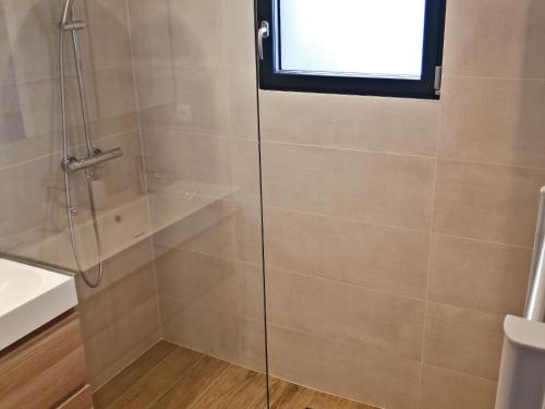 une douche avec une porte vitrée dans une salle de bain dans l'établissement Maison rénovée au calme, proche plage & commerces, Noirmoutier, 4 pers. - FR-1-823-1, à Noirmoutier-en-l'lle