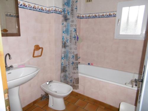 La salle de bains est pourvue de toilettes, d'un lavabo et d'une baignoire. dans l'établissement Maison à Barbâtre proche plage, animaux admis - FR-1-823-2, à Barbâtre