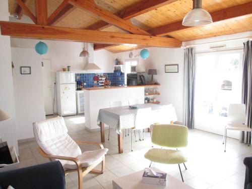 une cuisine et un salon avec une table et des chaises dans l'établissement Maison confortable à La Guérinière, proche plage, animaux admis - FR-1-823-4, à La Guérinière