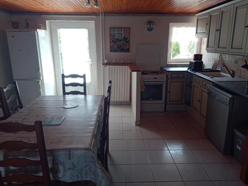 une cuisine avec une table en bois et une salle à manger dans l'établissement Maison 5 personnes à Barbâtre, proche plage, animaux admis - FR-1-823-3, à Barbâtre