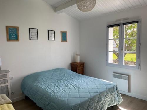 une chambre avec un lit bleu et une fenêtre dans l'établissement Maison Confortable Noirmoutier pour 6 Pers, Jardin Clôturé - FR-1-823-11, à Barbâtre