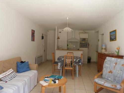 un salon avec un canapé et une table dans l'établissement À 200m de la plage, appart. avec jardin pour 4 pers., animaux et parking admis - FR-1-823-20, à La Guérinière