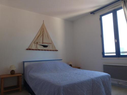 - une chambre dotée d'un lit avec une voile sur le mur dans l'établissement À 200m de la plage, appart. avec jardin pour 4 pers., animaux et parking admis - FR-1-823-20, à La Guérinière