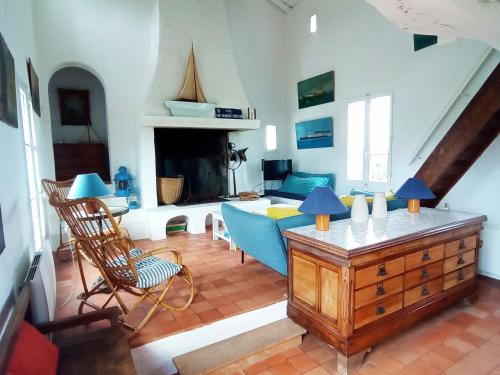 un salon avec des chaises bleues et une cheminée dans l'établissement Maison Noirmoutier 6 Pers, Bord de Mer - FR-1-823-21, à Noirmoutier-en-l'lle