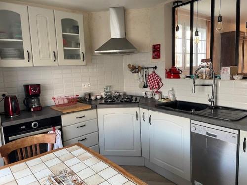 une cuisine avec des armoires blanches et un évier dans l'établissement Maison à Barbâtre - 6 personnes, animaux admis, parking, proche plage - FR-1-823-22, à Barbâtre