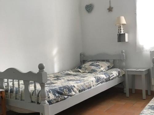 Ce lit se trouve dans une chambre dotée d'un mur blanc. dans l'établissement Maison mitoyenne 4 pers, près plage, animaux acceptés - FR-1-823-38, à La Guérinière