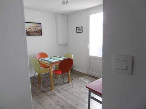 une salle à manger avec une table et quatre chaises dans l'établissement Maison cosy à Barbâtre, proche plage, jardin, 2 pers. - FR-1-823-39, à Barbâtre