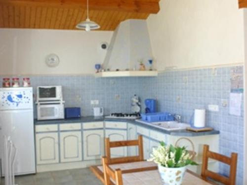 une cuisine avec des armoires blanches et un réfrigérateur blanc dans l'établissement Maison à L'Épine, proche Plage & Commerces, 4/6 Pers. - FR-1-823-44, à LʼÉpine