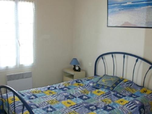 un lit avec une couette dessus dans une chambre dans l'établissement Maison à L'Épine, proche Plage & Commerces, 4/6 Pers. - FR-1-823-44, à LʼÉpine