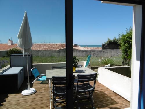 un patio avec une table et des chaises sur une terrasse dans l'établissement Rez-de-jardin 4 pers proche plage et port Noirmoutier - FR-1-823-32, à Noirmoutier-en-l'lle