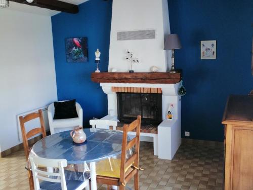une salle à manger avec une table et une cheminée dans l'établissement Maison à Noirmoutier proche plage, animaux admis - FR-1-823-34, à Noirmoutier-en-l'lle