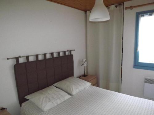 une chambre avec un grand lit avec des draps blancs dans l'établissement Maison mitoyenne confortable, proche plage et forêt - FR-1-823-35, à Barbâtre