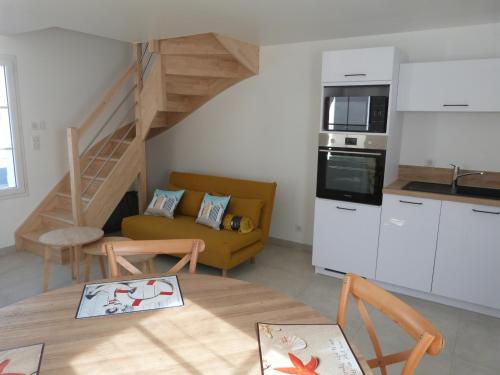 Il comprend une cuisine et un salon avec un canapé jaune. dans l'établissement Maison neuve à Barbâtre, proche plage pour 2 personnes - FR-1-823-36, à Barbâtre