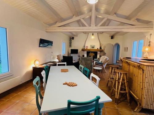 une salle à manger avec une table et des chaises blanches dans l'établissement Maison spacieuse à Barbâtre, proche plage, pour 8 personnes - FR-1-823-40, à Barbâtre