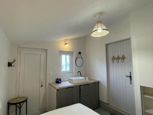 La salle de bains est pourvue d'un lavabo, d'un miroir et d'une porte. dans l'établissement Maison spacieuse à Barbâtre, proche plage, pour 8 personnes - FR-1-823-40, à Barbâtre