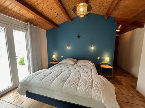 une chambre avec un grand lit avec un mur bleu dans l'établissement Maison spacieuse à Barbâtre, proche plage, pour 8 personnes - FR-1-823-40, à Barbâtre