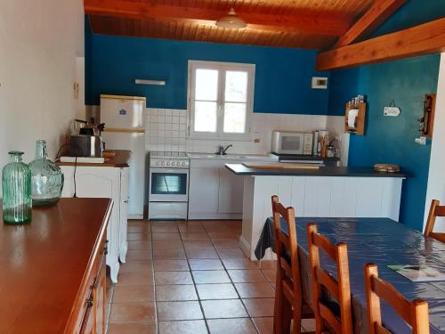 une cuisine avec des murs bleus et une table et des chaises dans l'établissement Maison 5 pers à Noirmoutier, proche plage - FR-1-823-46, à Barbâtre