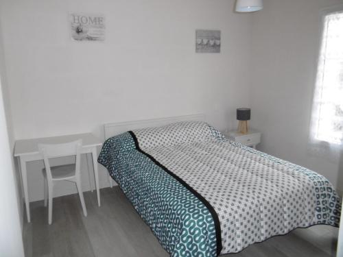 une chambre avec un lit et une table avec une chaise dans l'établissement Maison rénovée 6 pers, proche de la plage, terrasse et parking - FR-1-823-47, à LʼÉpine