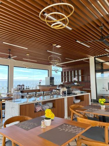 ein Restaurant mit Holzdecken und Tischen und Stühlen in der Unterkunft Ayers Hotel&Resto in Saba